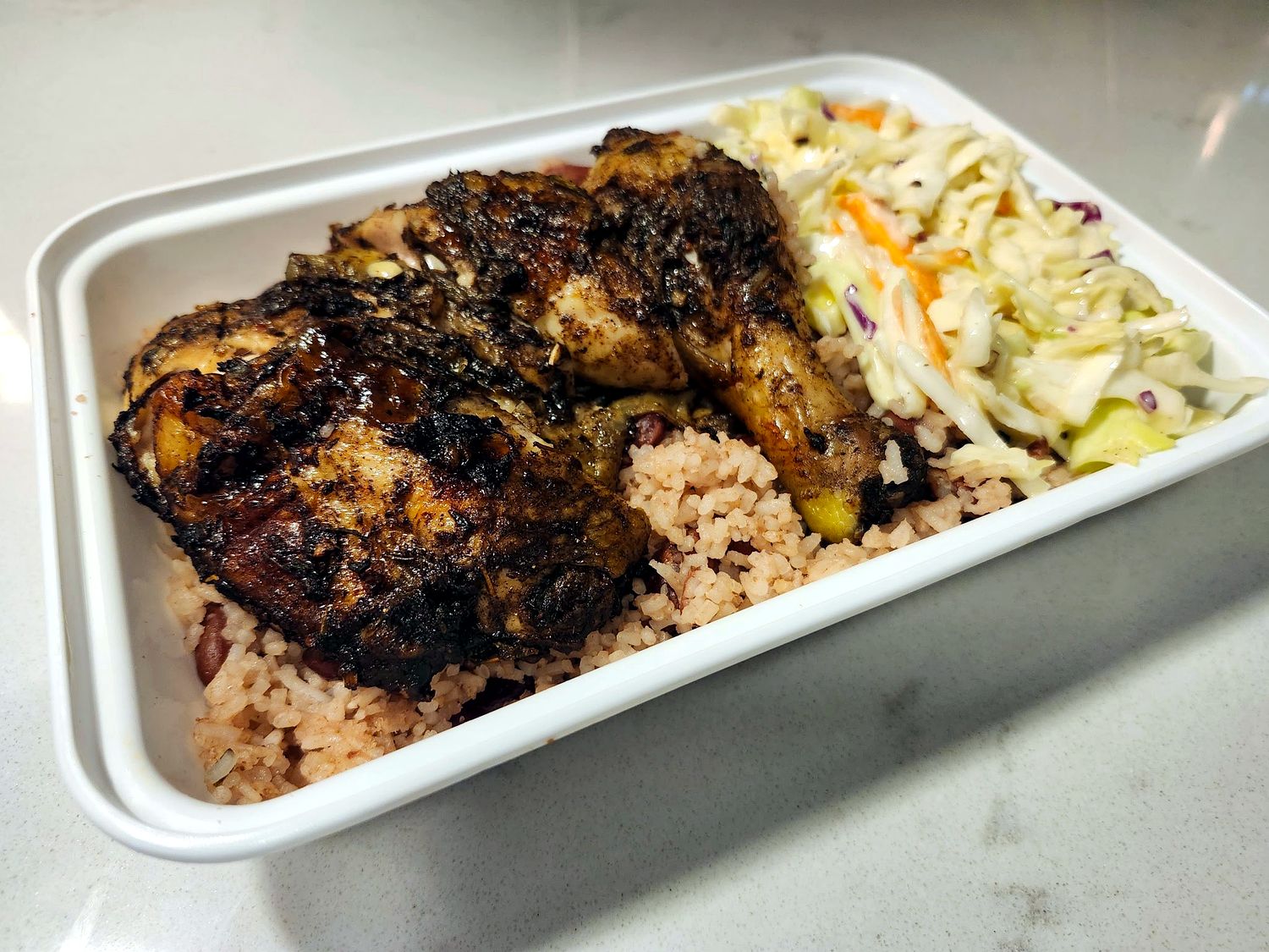 Jerk chicken with rice and peas and coleslaw